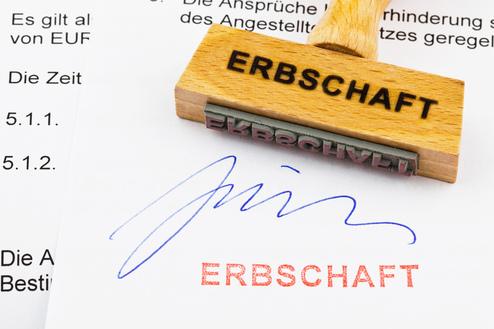 Holzstempel mit Aufschrift "ERBSCHAFT" auf einem Dokument, das eine Unterschrift und den Stempelabdruck zeigt.